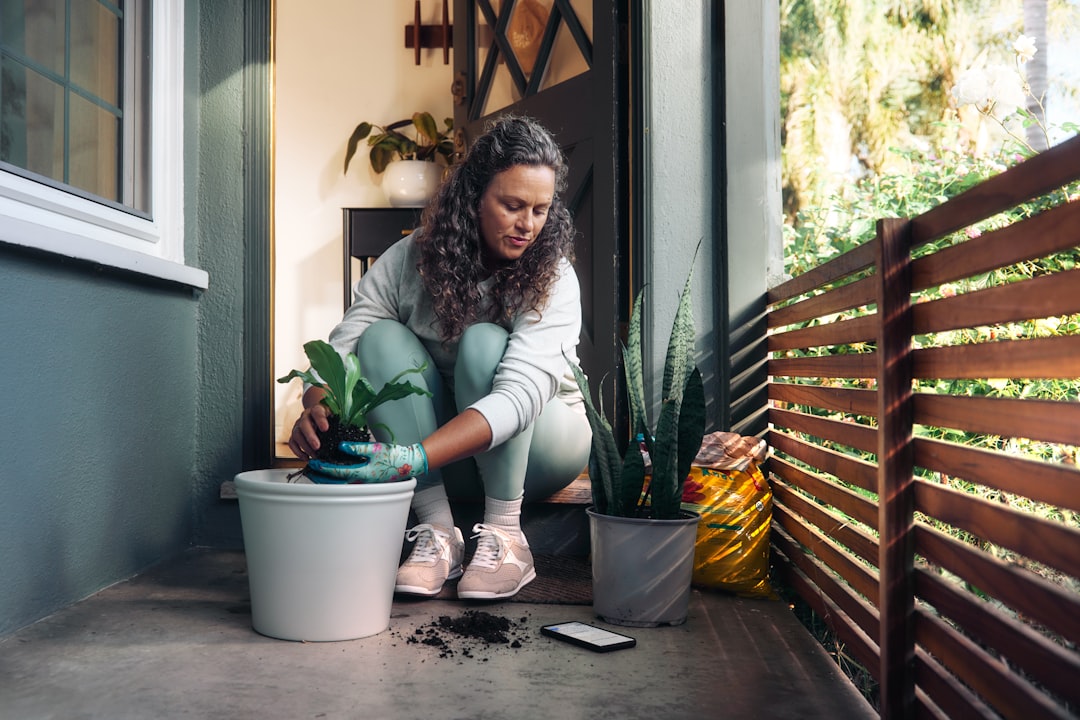 A woman applying compost to balcony plants after successful HDB composting at home