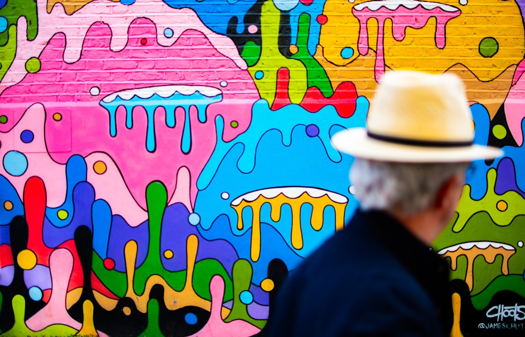 A young Singaporean artist standing in front of a completed street art mural in Kampong Glam