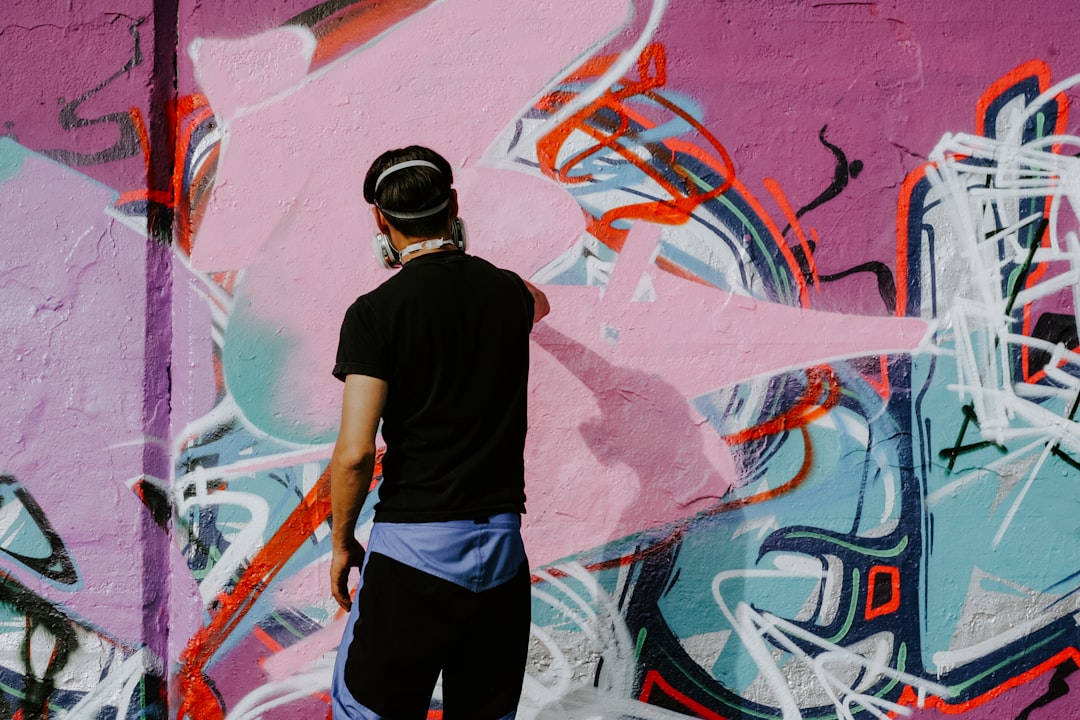 A workshop instructor guiding students through a street art technique in a Singapore creative programme