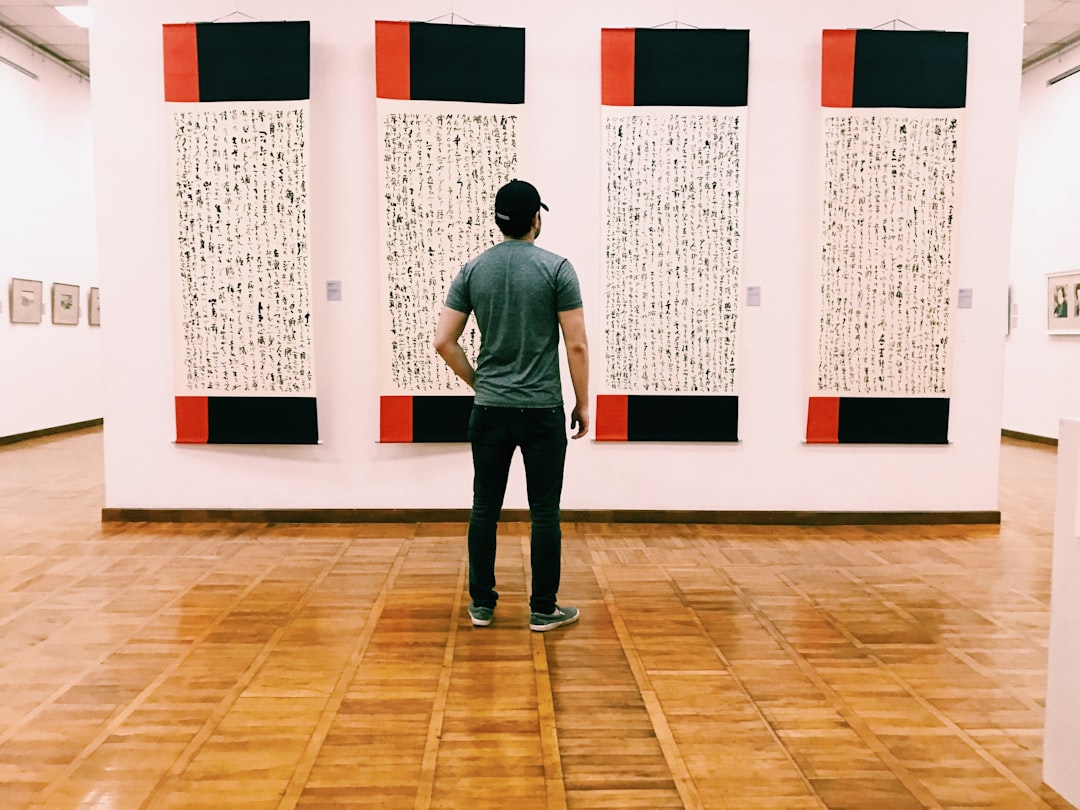 A serious collector reviewing acquisition options with an art advisory professional at an Asian gallery