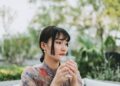 asian-woman-drinking-water-morning-unsplash - SINwebzine A professional woman beginning her morning routine in Singapore by drinking water at sunrise before the heat builds