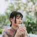 asian-woman-drinking-water-morning-unsplash - SINwebzine A professional woman beginning her morning routine in Singapore by drinking water at sunrise before the heat builds