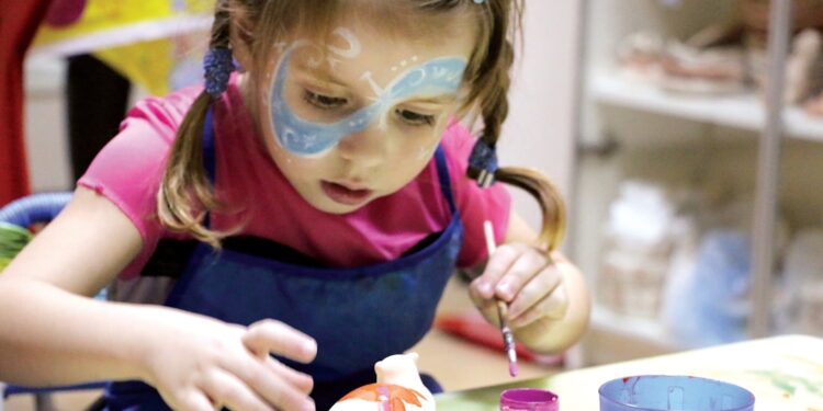 children-craft-workshop-unsplash - SINwebzine A child enjoying National Day activities at an arts and craft workshop in Singapore, painting red and white designs