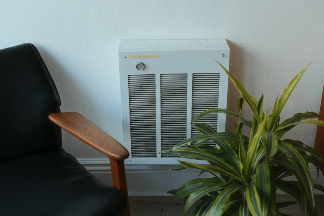A resident setting up a dehumidifier in a Singapore bedroom to control home humidity during the late-August monsoon season