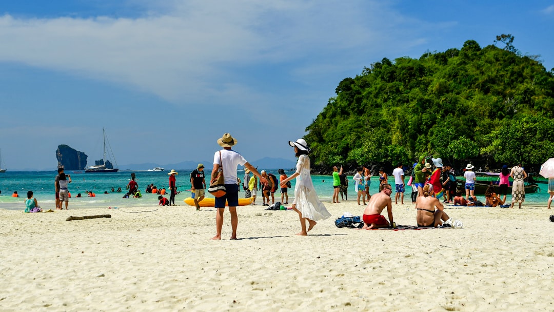 A family relaxing on a white sand beach at a resort, enjoying island escapes just a ferry ride from Singapore