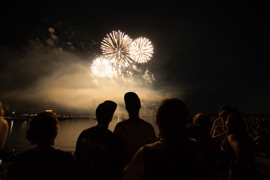 A family with young children watching National Day activities fireworks light up the Singapore skyline from a waterfront view