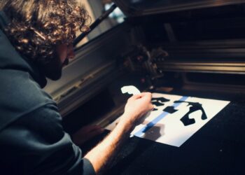 A man carefully pulls ink across a frame during a screen printing workshop in Singapore