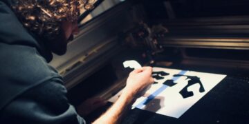A man carefully pulls ink across a frame during a screen printing workshop in Singapore