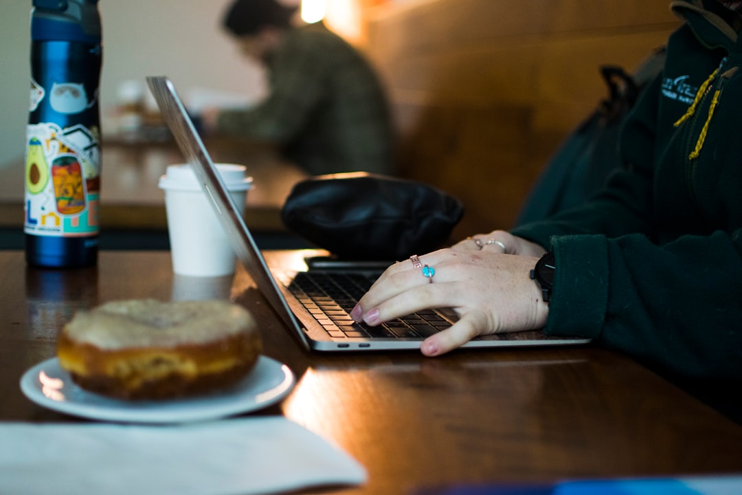 A filmmaker edits footage from a short film on a laptop at a Singapore café