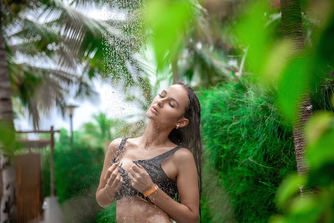 A person in a bright tropical outdoor setting, reinforcing consistent sunscreen habits against UV damage