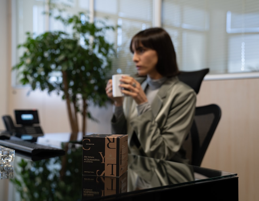 A Singapore professional woman sitting quietly at her desk as part of a mindful morning routine before a busy workday begins
