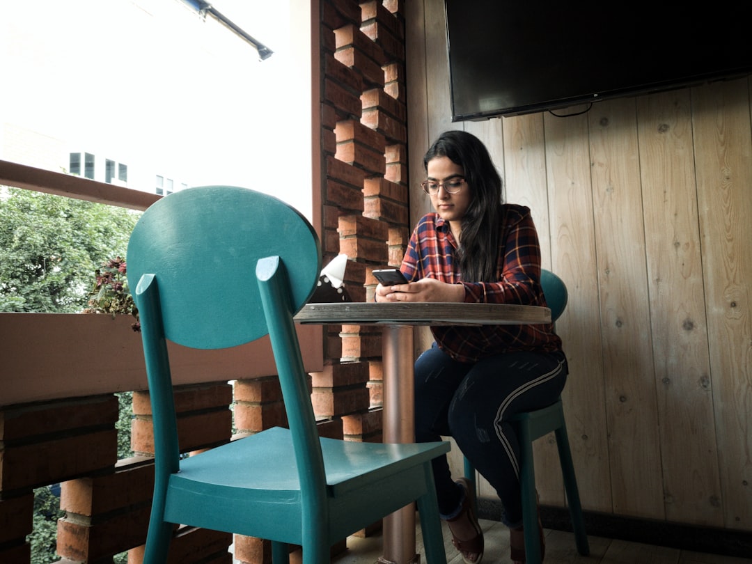 A woman adds a linen jacket inside a cool cafe, managing the indoor-outdoor contrast created by Singapore heat