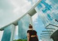 woman-linen-outfit-singapore-street-unsplash - SINwebzine A woman wearing a loose linen outfit walks along a shaded Singapore street, dressed practically for Singapore heat
