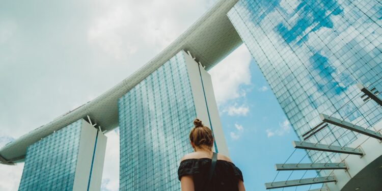 woman-linen-outfit-singapore-street-unsplash - SINwebzine A woman wearing a loose linen outfit walks along a shaded Singapore street, dressed practically for Singapore heat