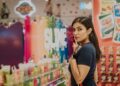 woman-reading-product-label-supermarket-unsplash - SINwebzine A woman reads a zero waste label on a household product in a Singapore supermarket aisle.