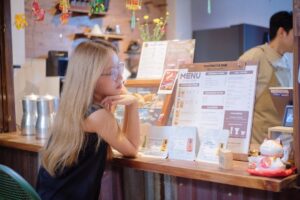 A woman carefully reviews a buffet menu at a Singapore National Day celebration, making informed gluten-free choices