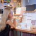 A woman carefully reviews a buffet menu at a Singapore National Day celebration, making informed gluten-free choices