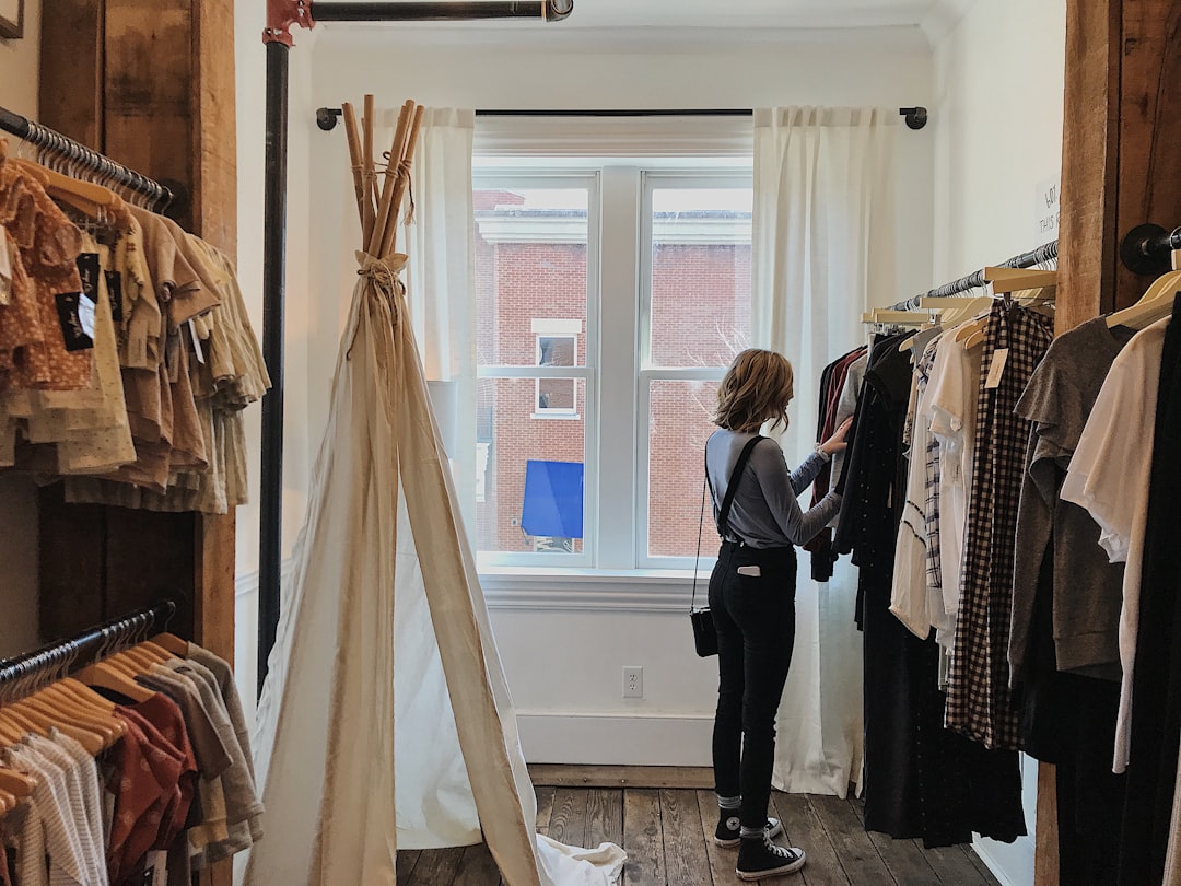 A shopper browses natural-fabric garments in a sustainable clothing store, building her capsule wardrobe for Singapore heat