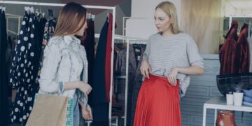 woman-thrift-store-red-clothing-unsplash - SINwebzine A woman browsing red garments on a rail while building a secondhand outfit for National Day in Singapore