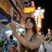 young-woman-filming-street-unsplash - SINwebzine A man uses her smartphone to begin a short film practice on a busy Singapore street