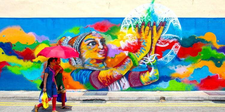 artist-painting-mural-wall-singapore-unsplash - SINwebzine A local artist painting a large Marina Bay mural on an outdoor wall near the waterfront district