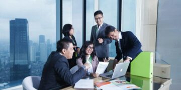 asian-business-professionals-in-meeting-unsplash - SINwebzine Two corporate executives reviewing F1 hospitality packages at a trackside suite during the Singapore Grand Prix weekend