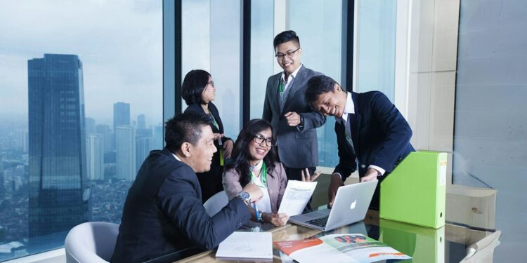 asian-business-professionals-in-meeting-unsplash - SINwebzine Two corporate executives reviewing F1 hospitality packages at a trackside suite during the Singapore Grand Prix weekend