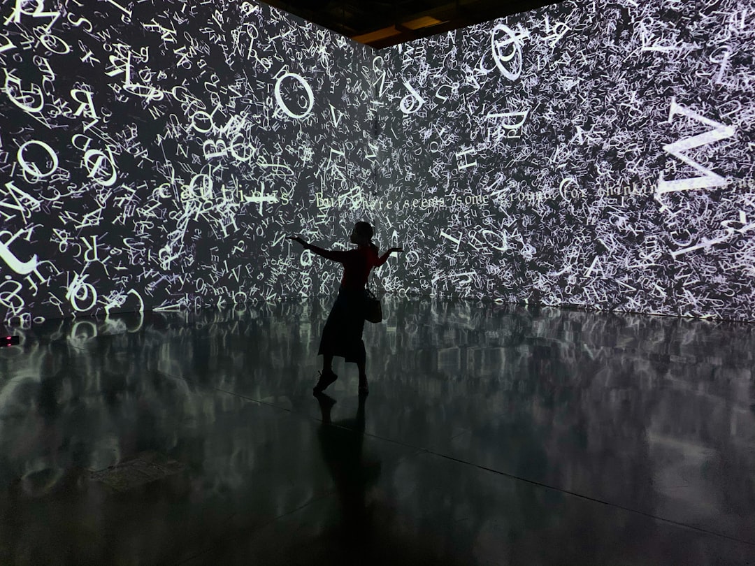 A young girl reaching out to touch a glowing digital art installation inside one of Singapore's children's museums.