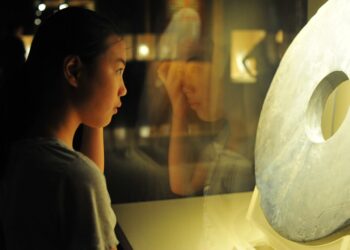 A young child digging in the Dino Pit at one of Singapore's best children's museums, smiling with excitement at a discovery.