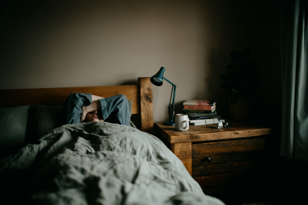 A man reducing screen exposure before bed as part of a sleep reset routine in a Singapore apartment