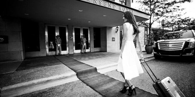 people-arriving-hotel-unsplash - SINwebzine A hotel concierge greets arriving guests during the Singapore Grand Prix race weekend at a Marina Bay property