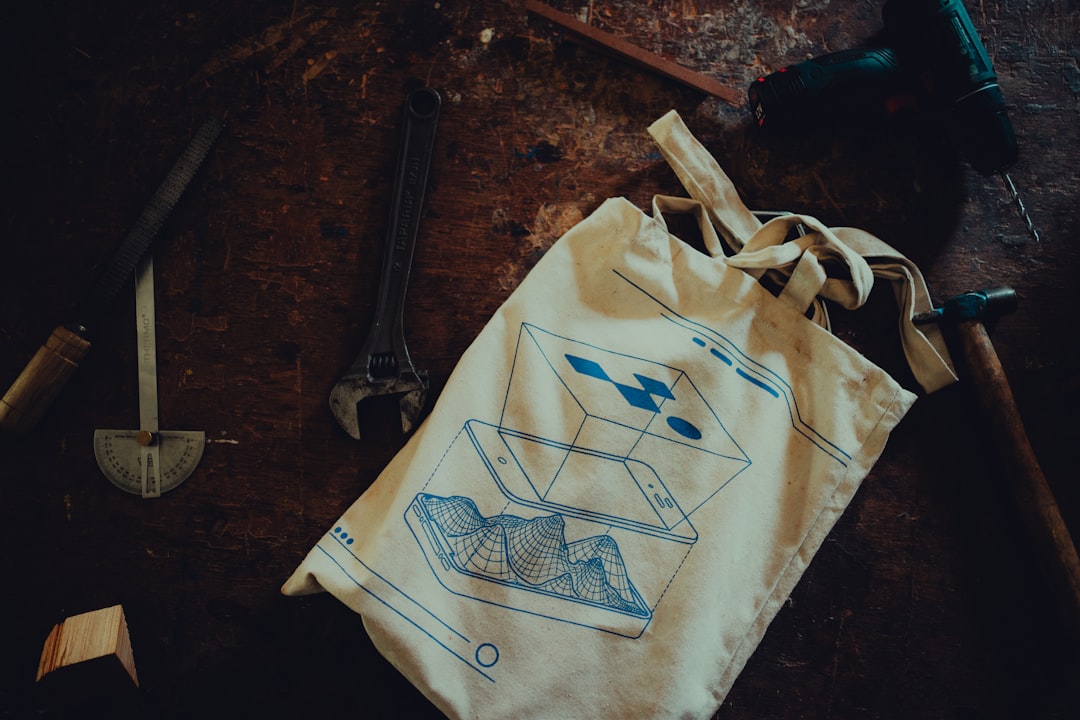 A beginner screen printing a tote bag at a Singapore printmaking studio, holding up her finished handmade piece