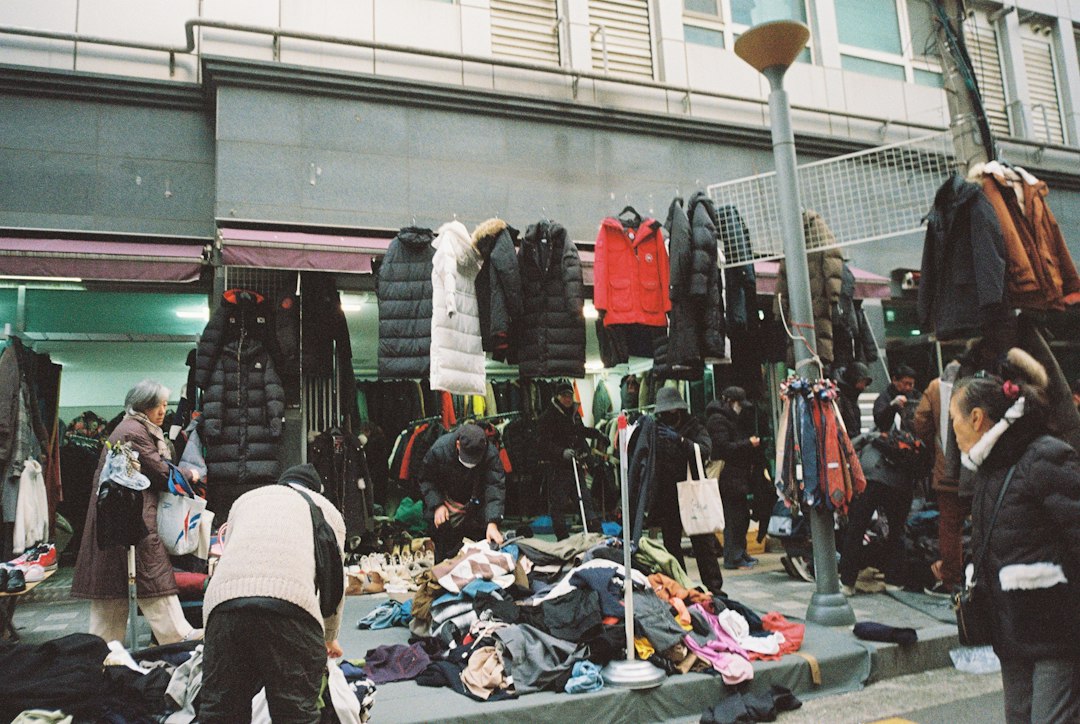 A woman arranging preloved clothing at a market stall, showing the social side of Singapore's secondhand platforms scene.
