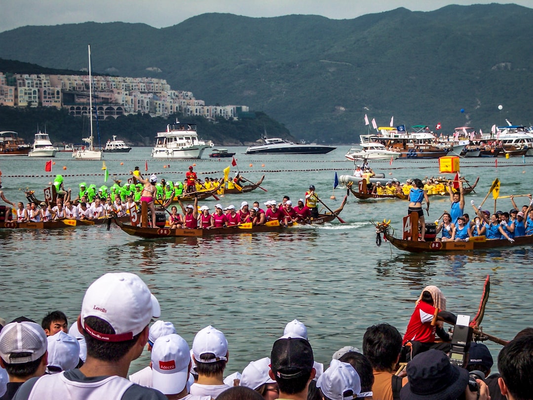 Un team di pagaiatori che gareggia nei festival di giugno, le gare di dragon boat di Singapore al Bedok Reservoir, con i tamburi che battono.
