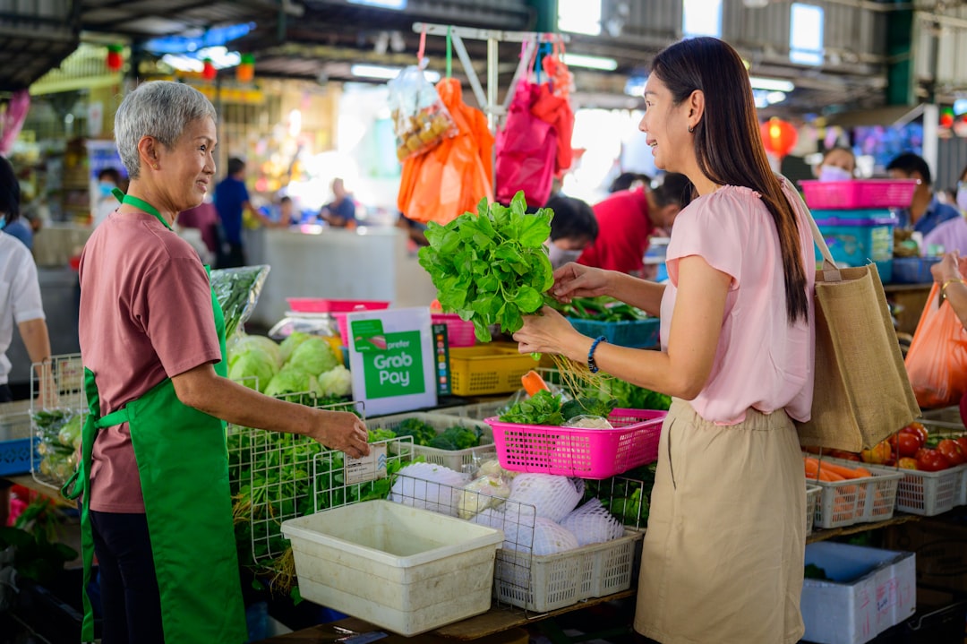 Elderly hawker serves at a traditional Singapore hawker centre,representing one of the city's most enduring Singapore rituals