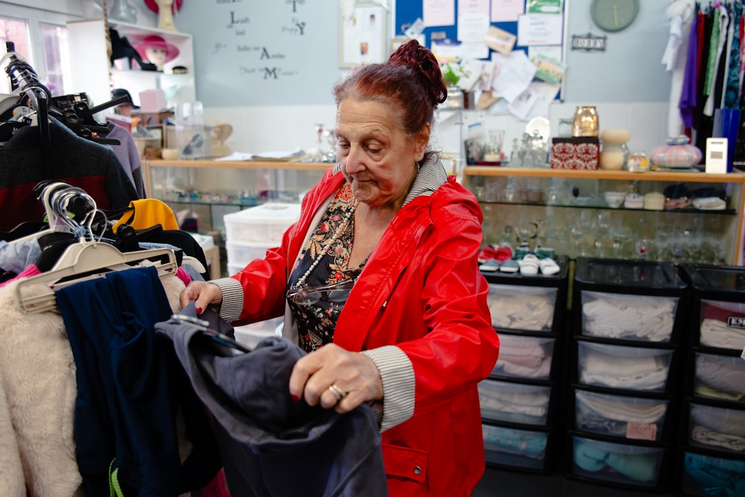 A woman carefully inspects a rack of preloved garments while thrifting designer pieces in a Singapore vintage shop
