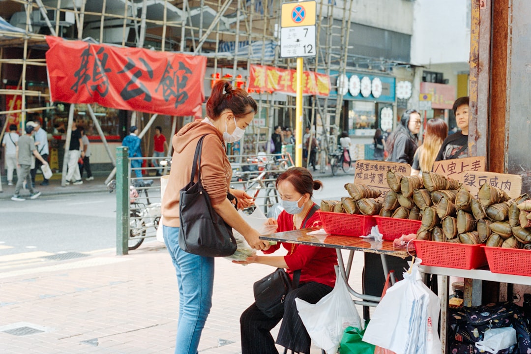 A woman selecting rice dumplings at a Singapore market stall during Dragon Boat Festival season