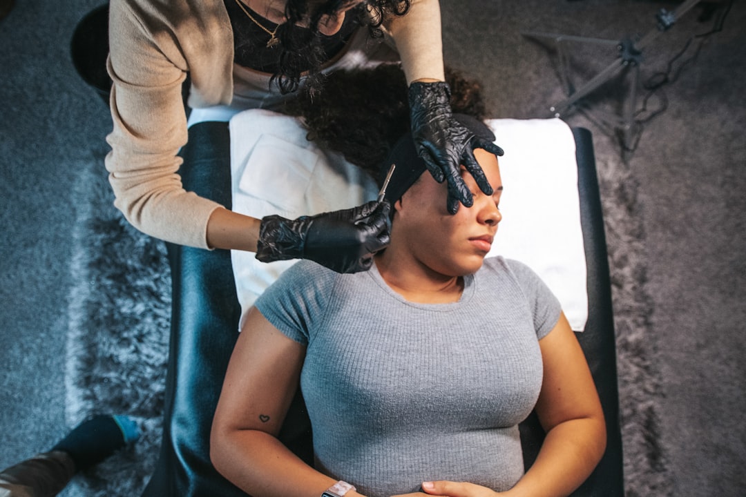 A board-certified dermatologist examines a patient's skin during a Singapore dermatology consultation in a clinical setting