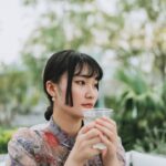 Una mujer profesional que comienza su rutina matutina en Singapur bebiendo agua al amanecer antes de que aumente el calor