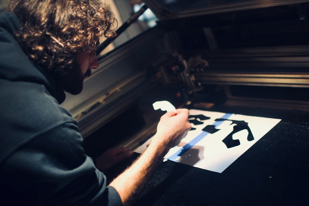 A man carefully pulls ink across a frame during a screen printing workshop in Singapore