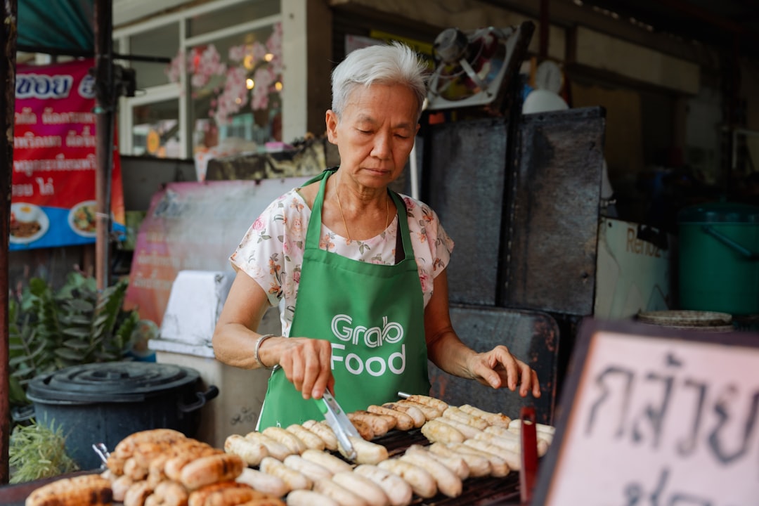 A woman enjoying a plate of food at a Singapore vegetarian hawker stall in a busy food centre