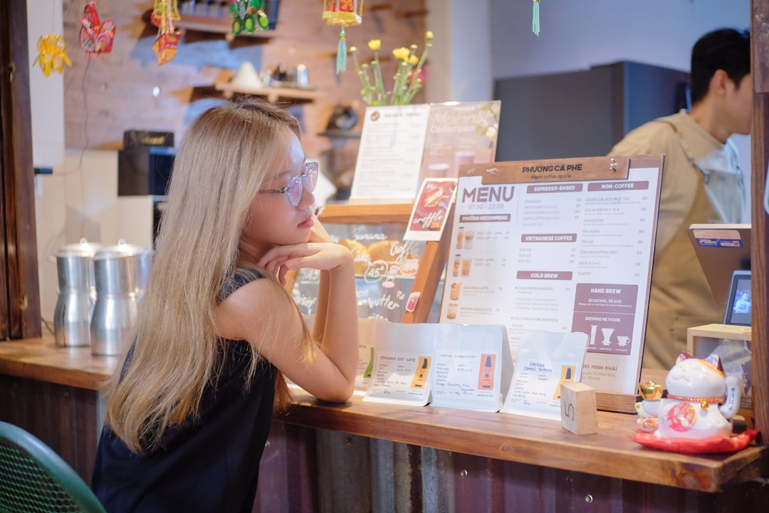 A woman carefully reviews a buffet menu at a Singapore National Day celebration, making informed gluten-free choices