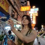 Un hombre usa su teléfono inteligente para comenzar una práctica de cortometraje en una calle concurrida de Singapur.