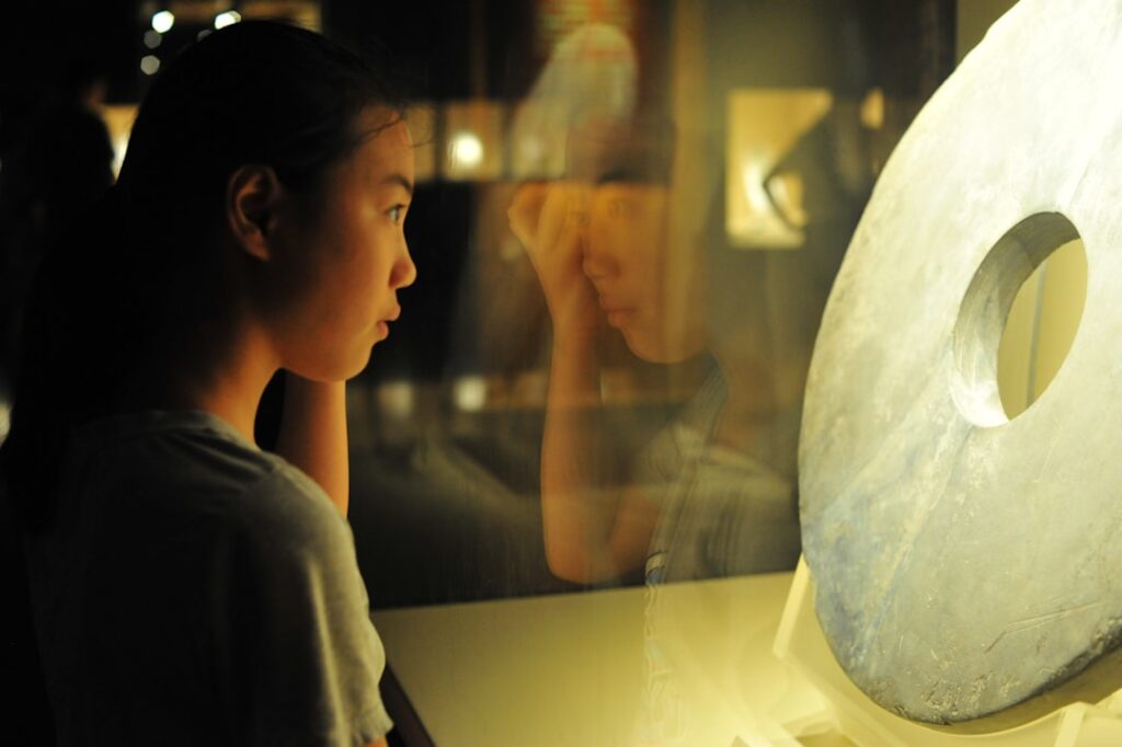 Un niño pequeño cavando en el Dino Pit en uno de los mejores museos infantiles de Singapur, sonriendo con entusiasmo ante un descubrimiento.